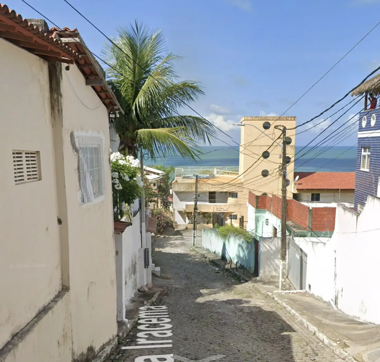 Descendo a rua, o mar já aparece ao fundo.